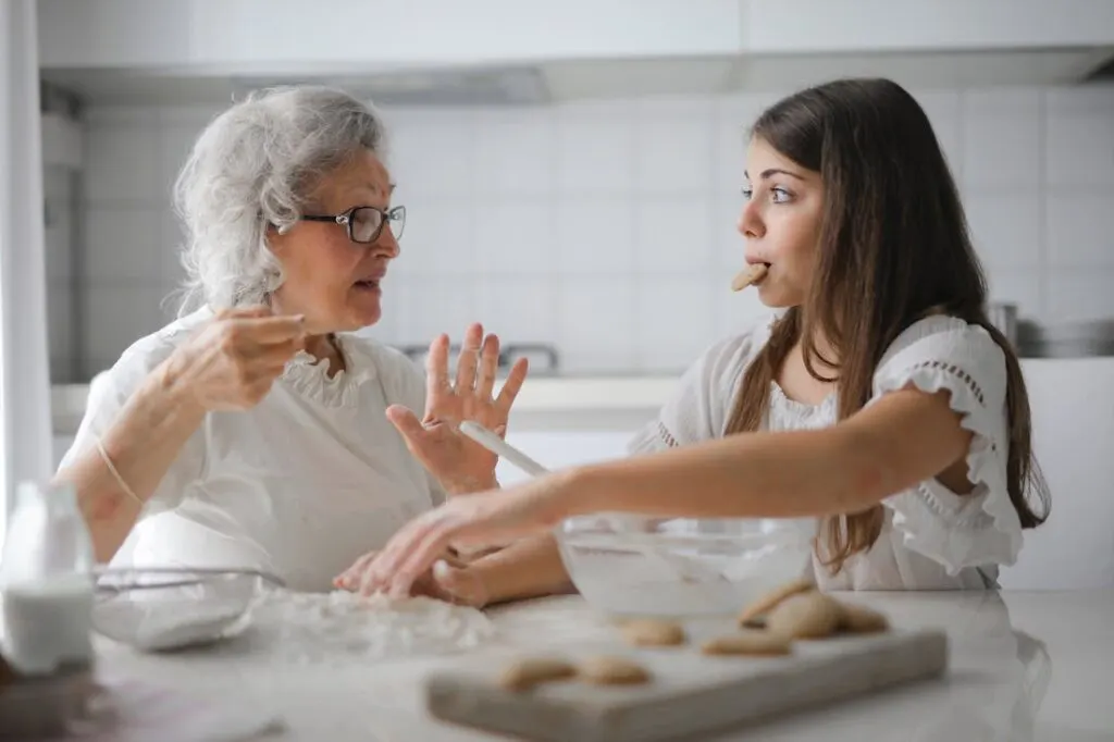 Keeping your loved one active, like this daughter is doing by cooking with her elderly mom, is a key part of caring for aging family members