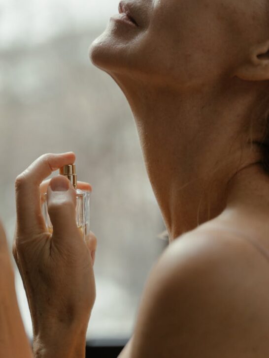 A woman spraying natural perfumes on her neck