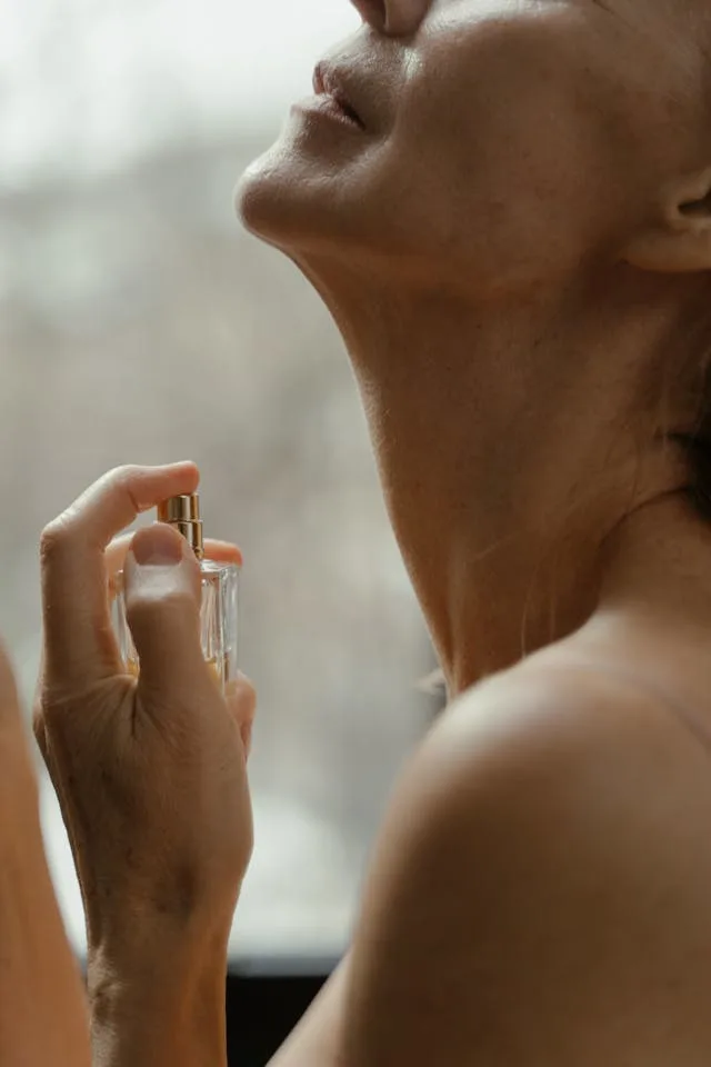 A woman spraying natural perfumes on her neck