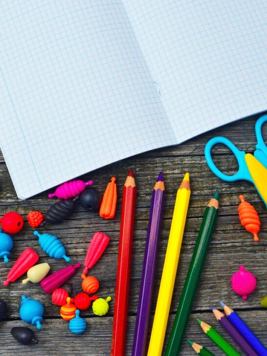 a bunch of colorful school supplies on a wood background