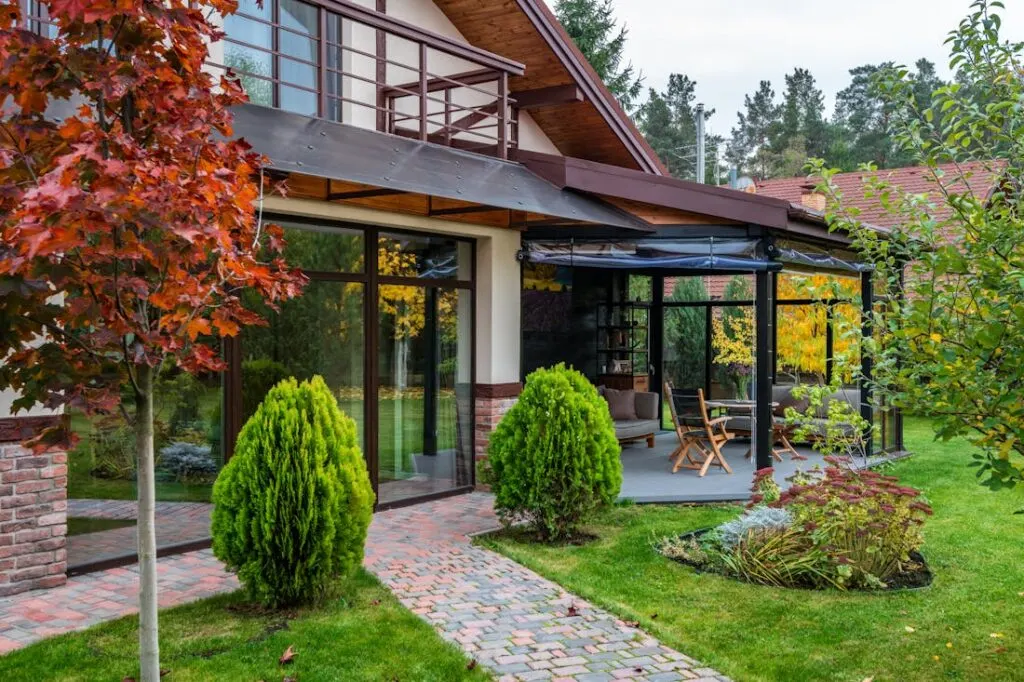 The back of a house with a covered patio and well-designed backyard landscaping ideas including the right plants and hardscaping.