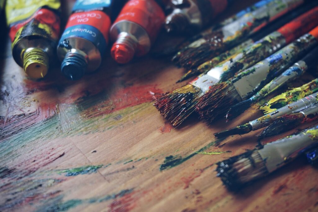 paint and brushes on a table used for painting 