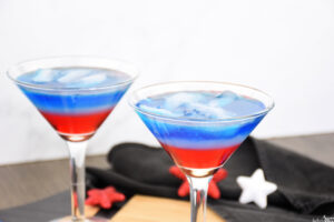 Two red, white and blue cocktails in martini glasses