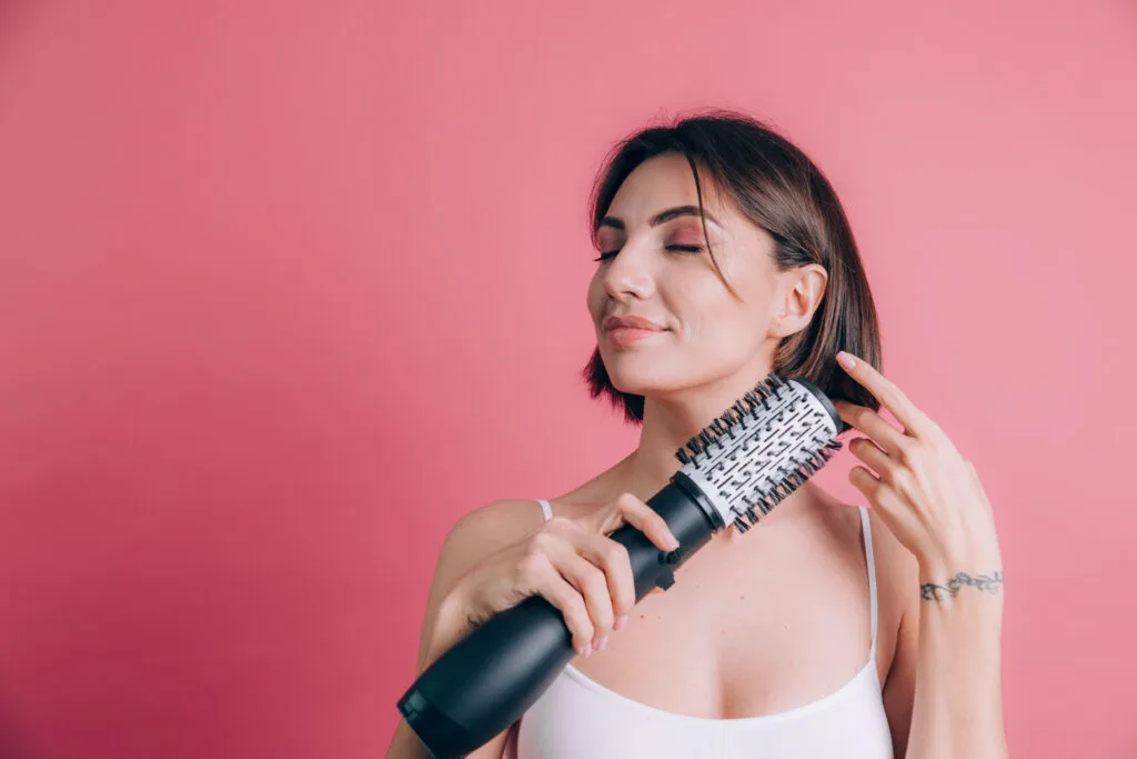 Three women with lovely long straight hair made beautiful by using a hair straightening brush