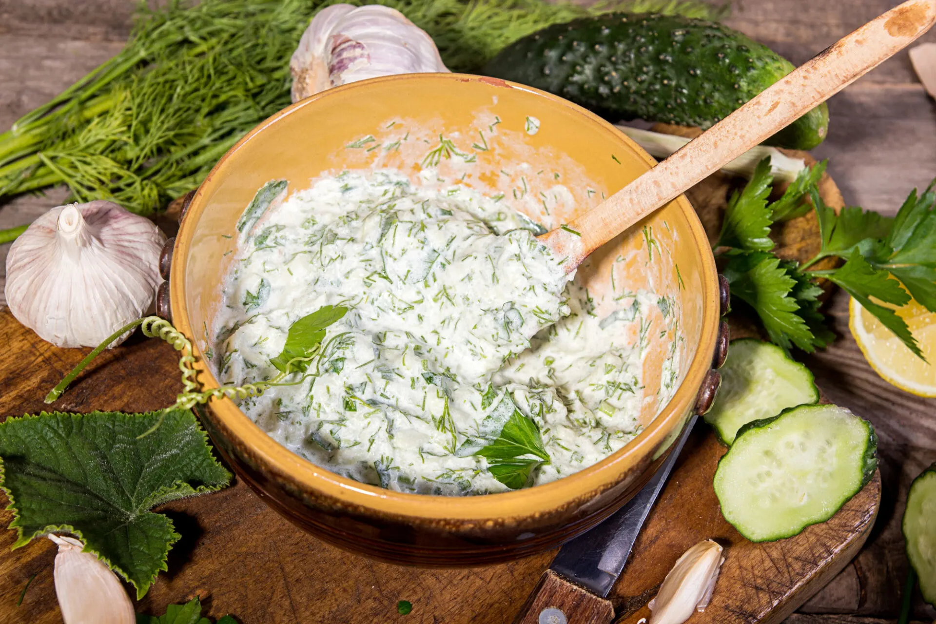 Dip sauce appetizer tzatziki of cucumber, yogurt, garlic, lemon and dill. Creece cuisine. Old wooden rustic background.