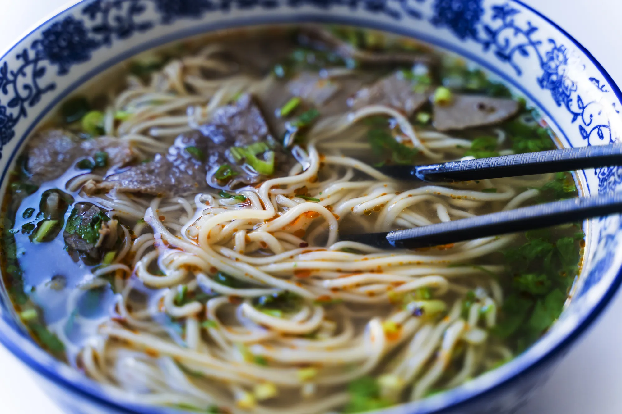 beef and noodle soup in blue bowl