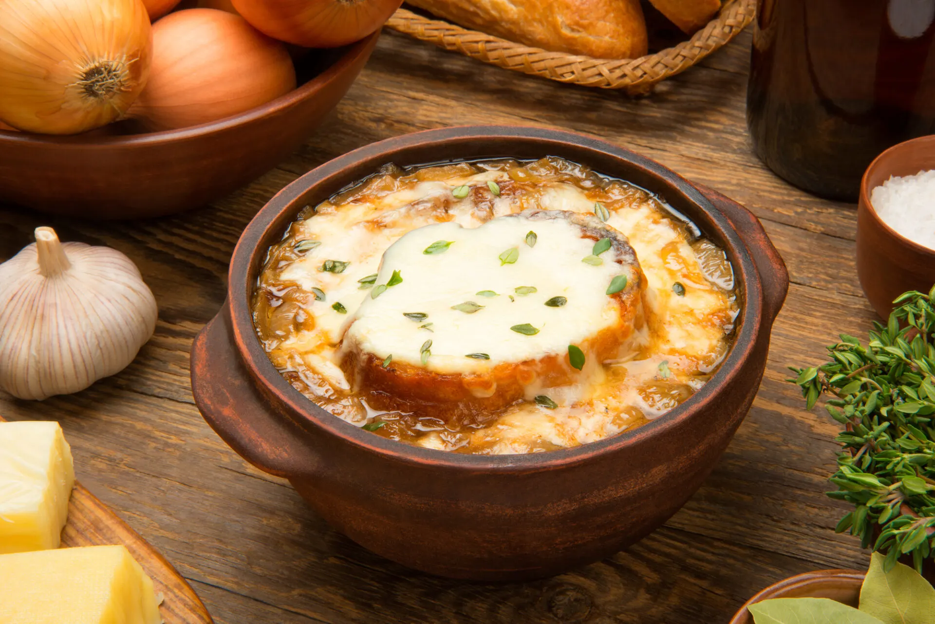french onion soup in brown bowl topped with bread