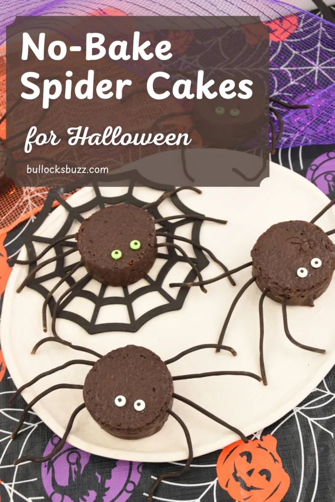Several no-bake chocolate spider cakes with licorice legs and candy eyes sitting on a plate on a purple and orange Halloween background