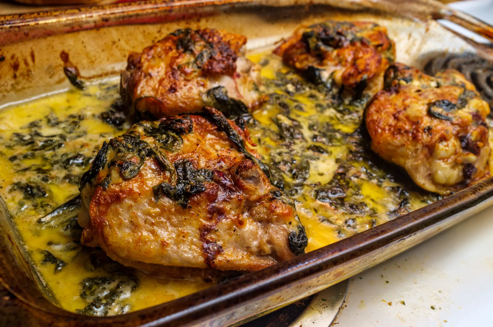 Italian lemon butter chicken thighs with creamy garlic sauce in baking casserole dish