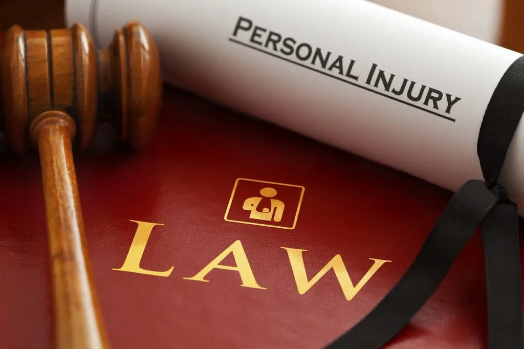 a law book with a judge's gavel and a paper with the words settle a personal injury claim