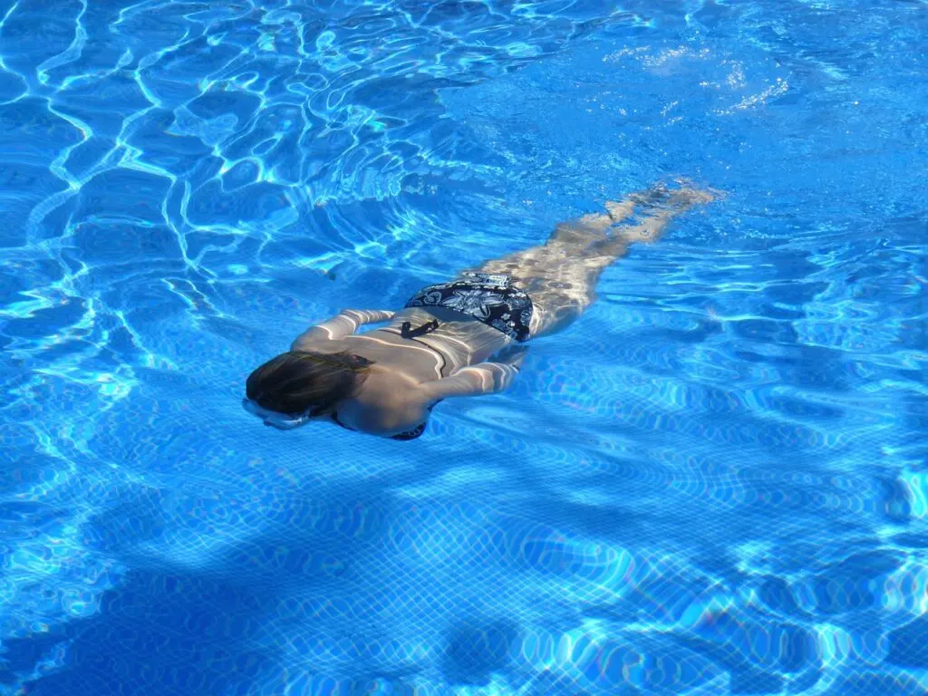 A woman swimming underwater using basic water safety skills to remain safe