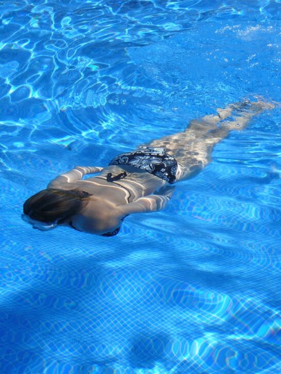 A woman swimming underwater using basic water safety skills to remain safe