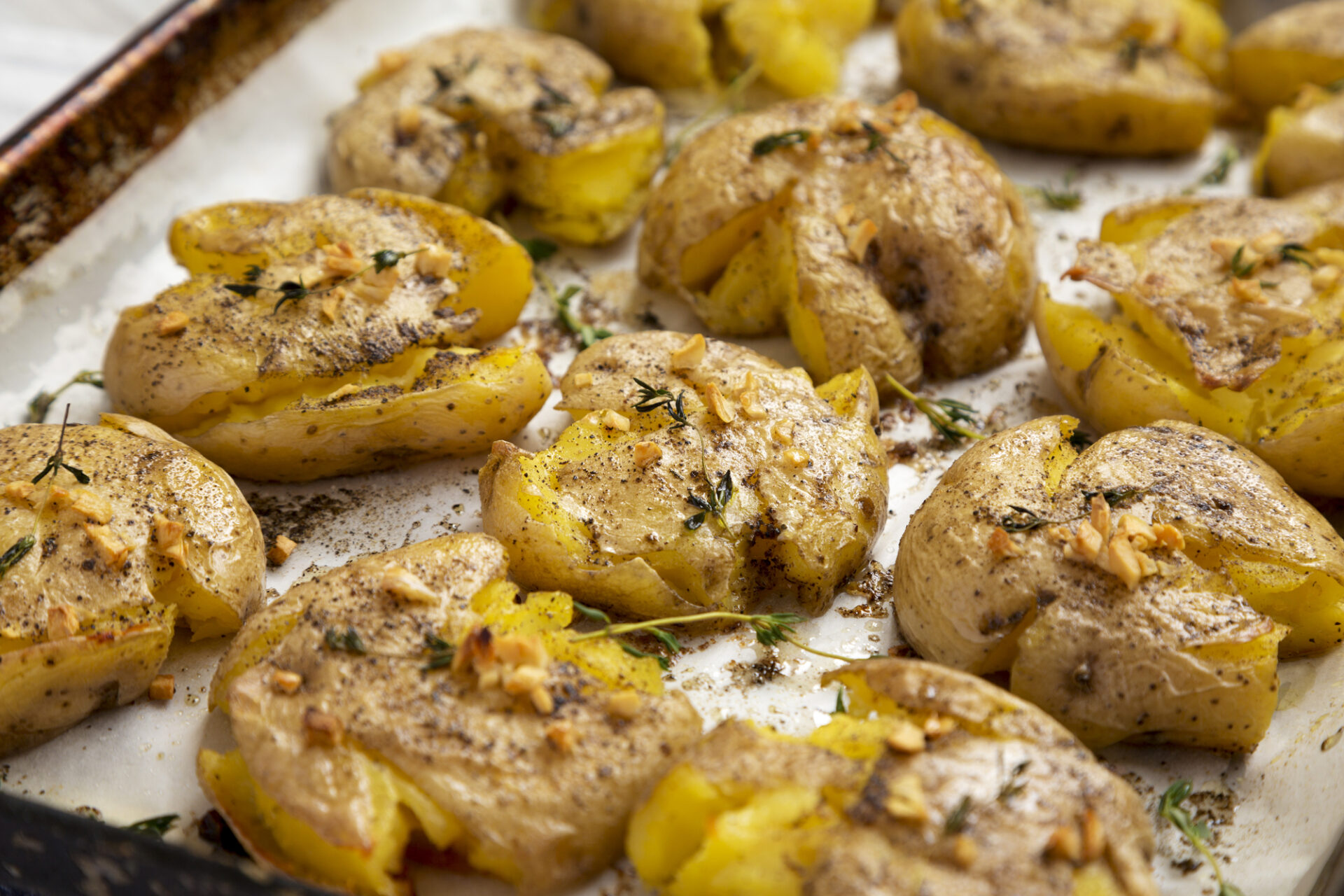 Homemade garlic thyme smashed potatoes, side view. Close-up.
