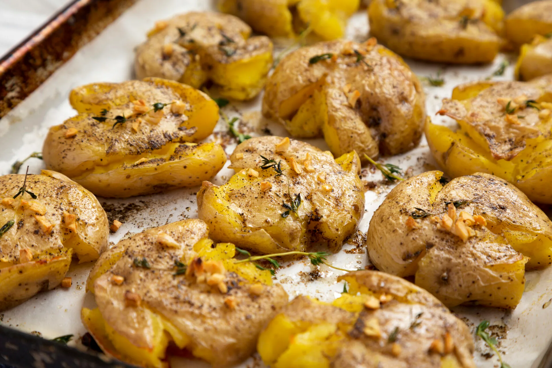 Homemade garlic thyme smashed potatoes, side view. Close-up.