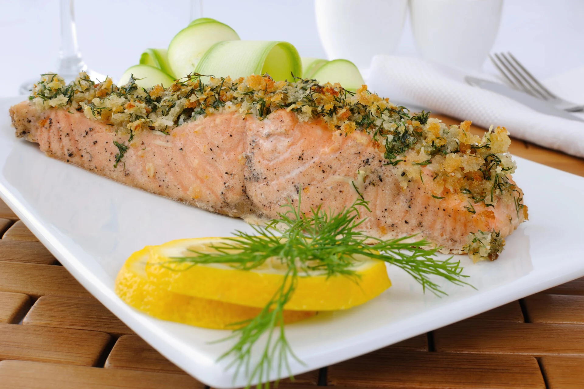 Baked Salmon with Garlic Parmesan Crust on a white place with slices of lemon