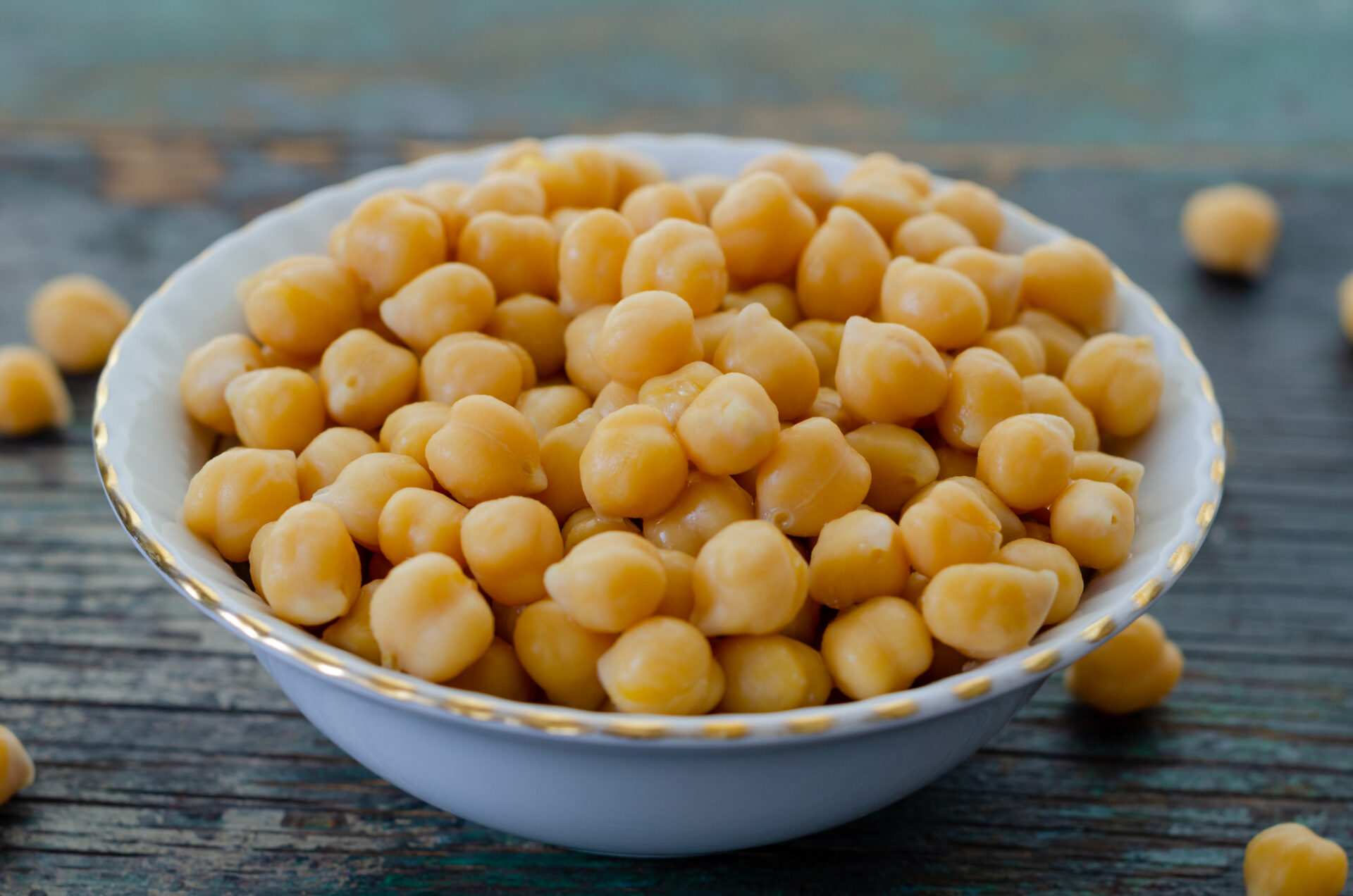 A Bowl of cooked chickpeas on the wooden table -, close up