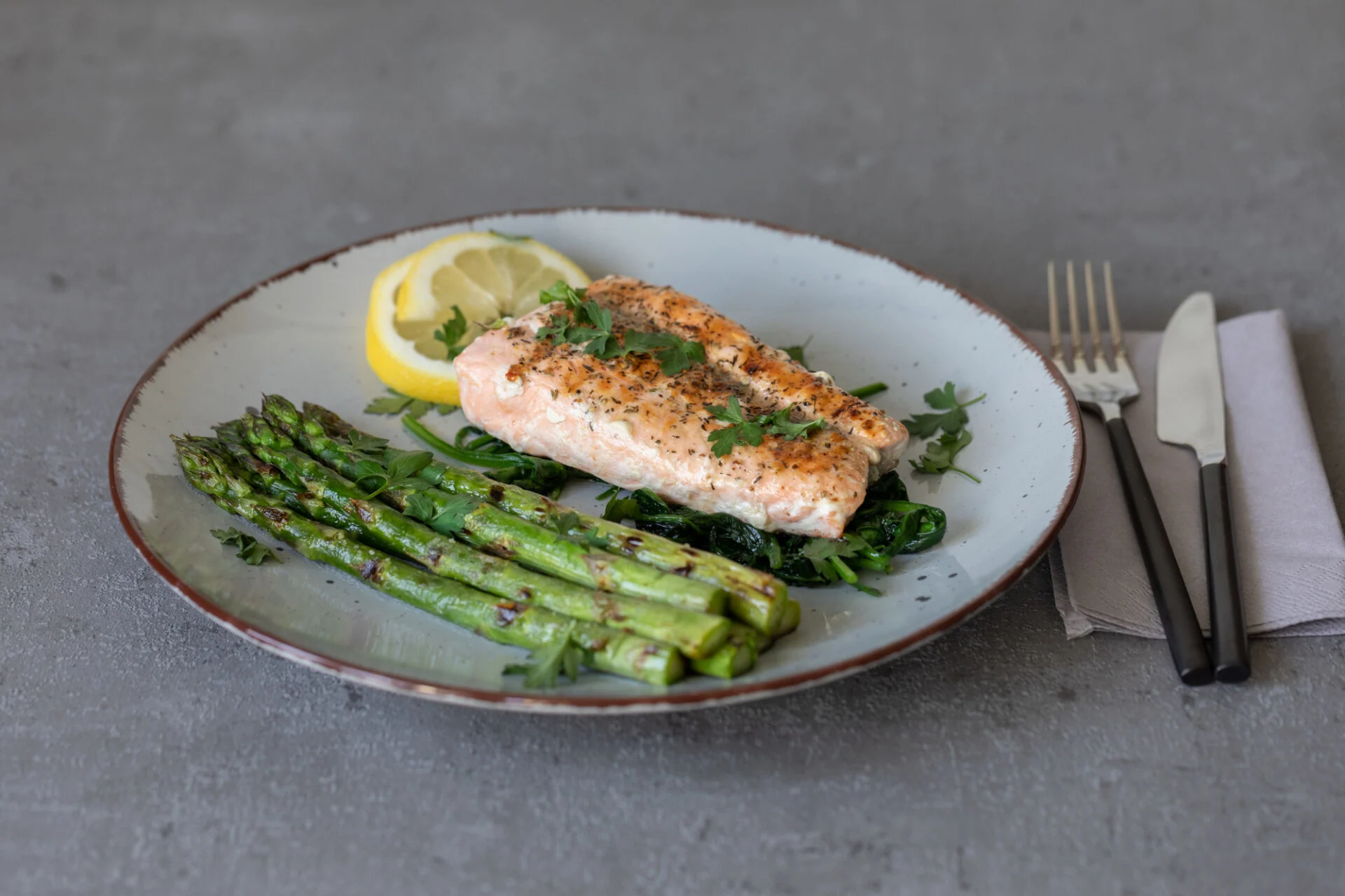 salmon with green asparagus on a grey table and decoration