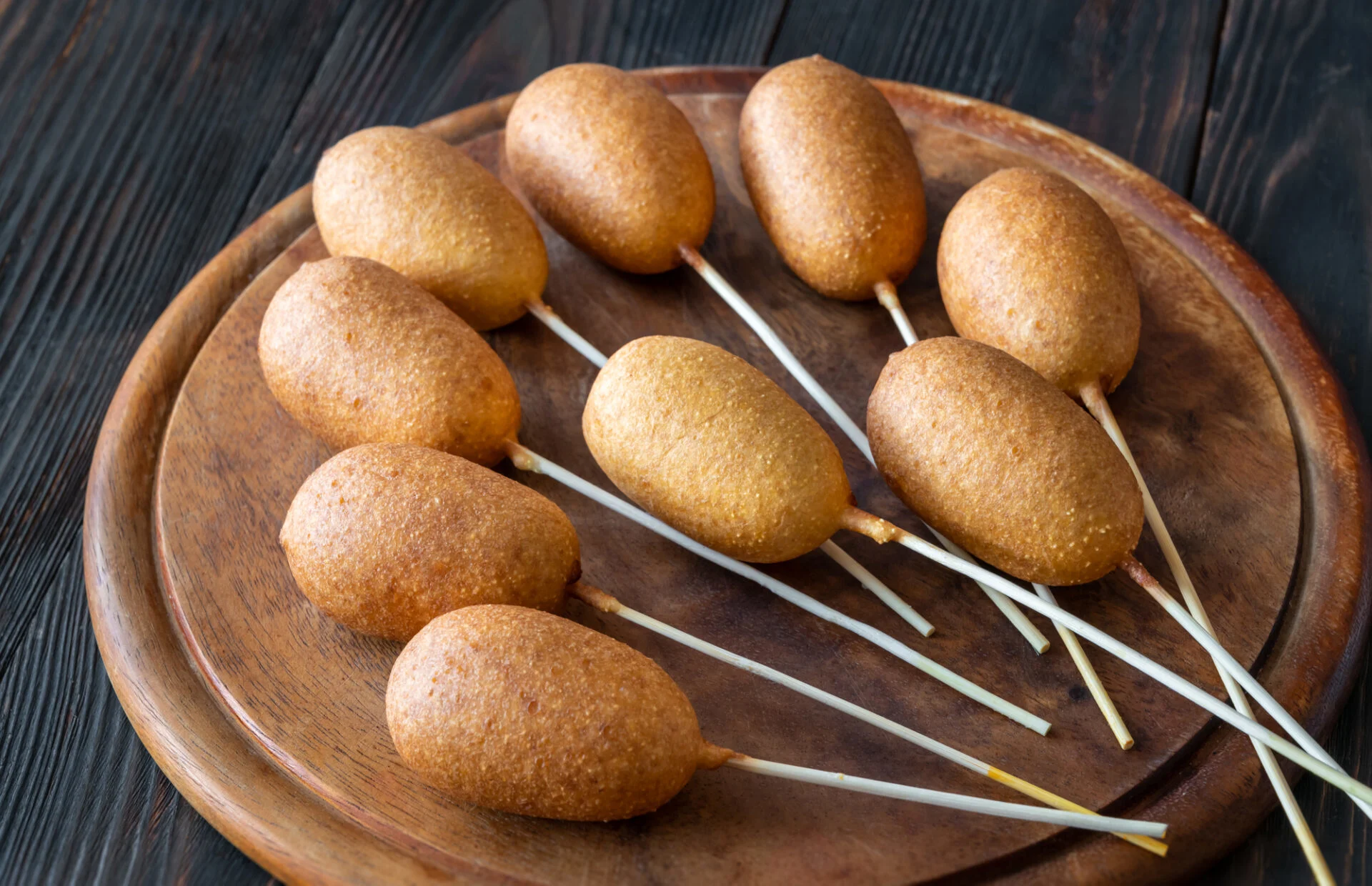 Bunch of mini corn dogs on wooden board