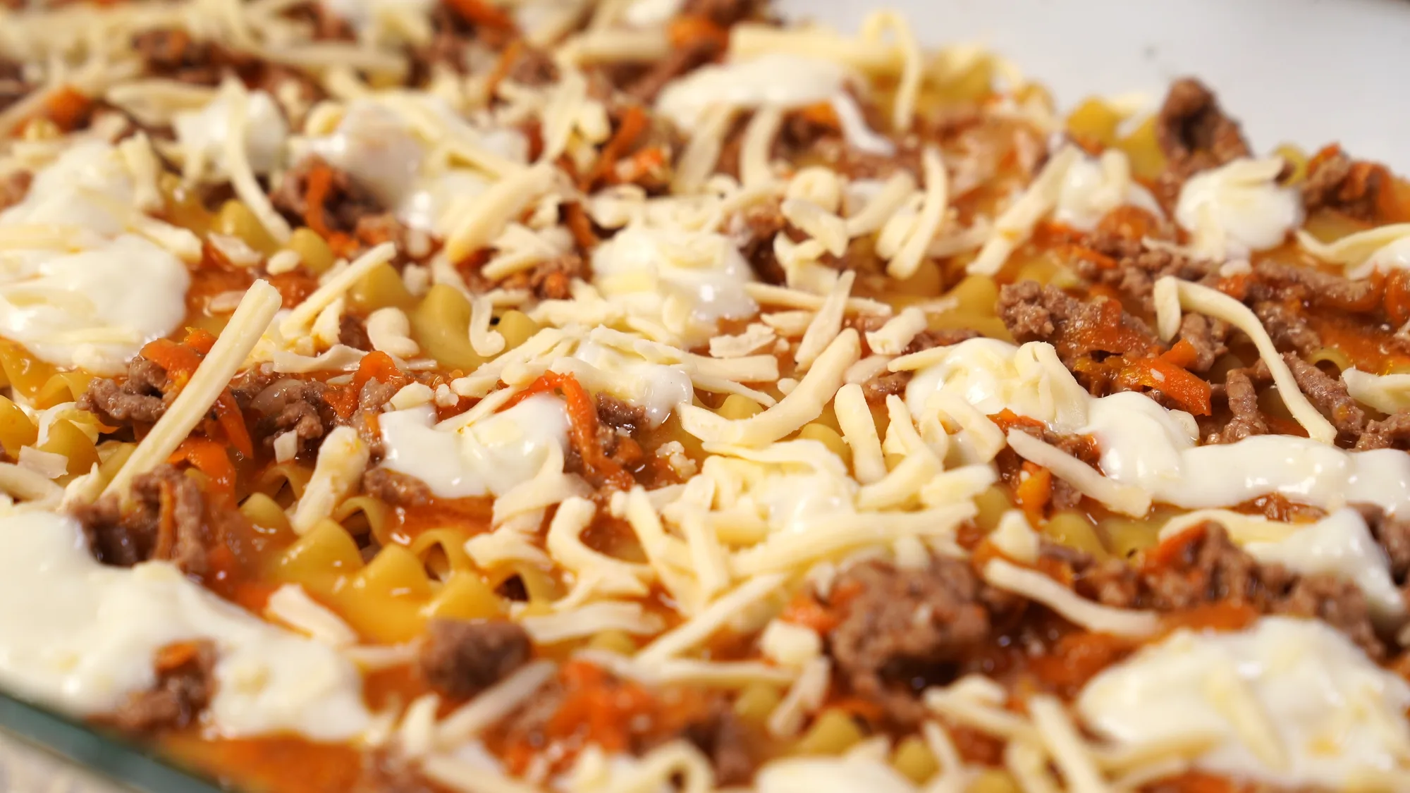 step-by-step laying of layers of lasagna into a baking dish. pasta casserole with red minced meat sauce (bolognese) and white sauce (bechamel). Italian cuisine at home.