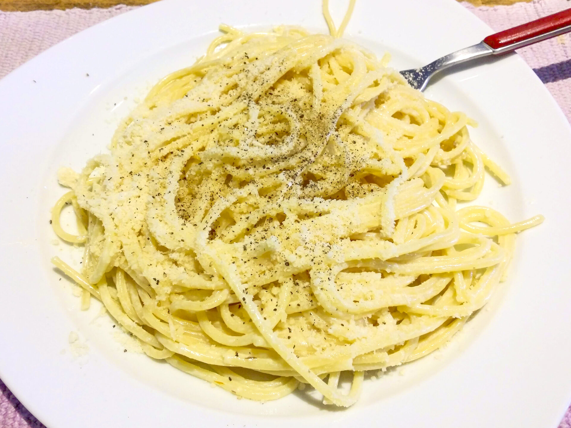 steaming plate of spaghetti, pasta for the party lunch in Italy, seasoned with alfredo, butter, cheese, pepper and herbs