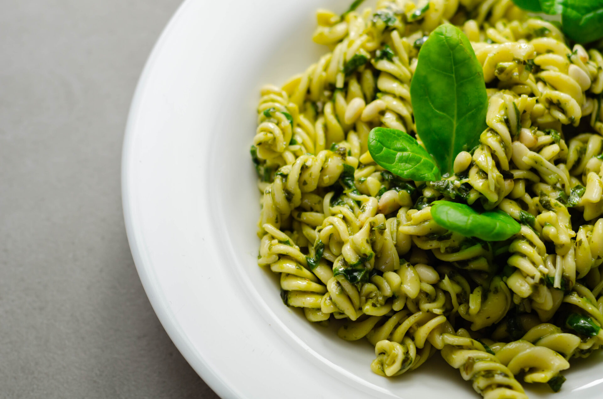 Pesto and pine nut pasta salad, fusilli pasta with regato cheese and baby spinach coated in basil pesto, Italian food