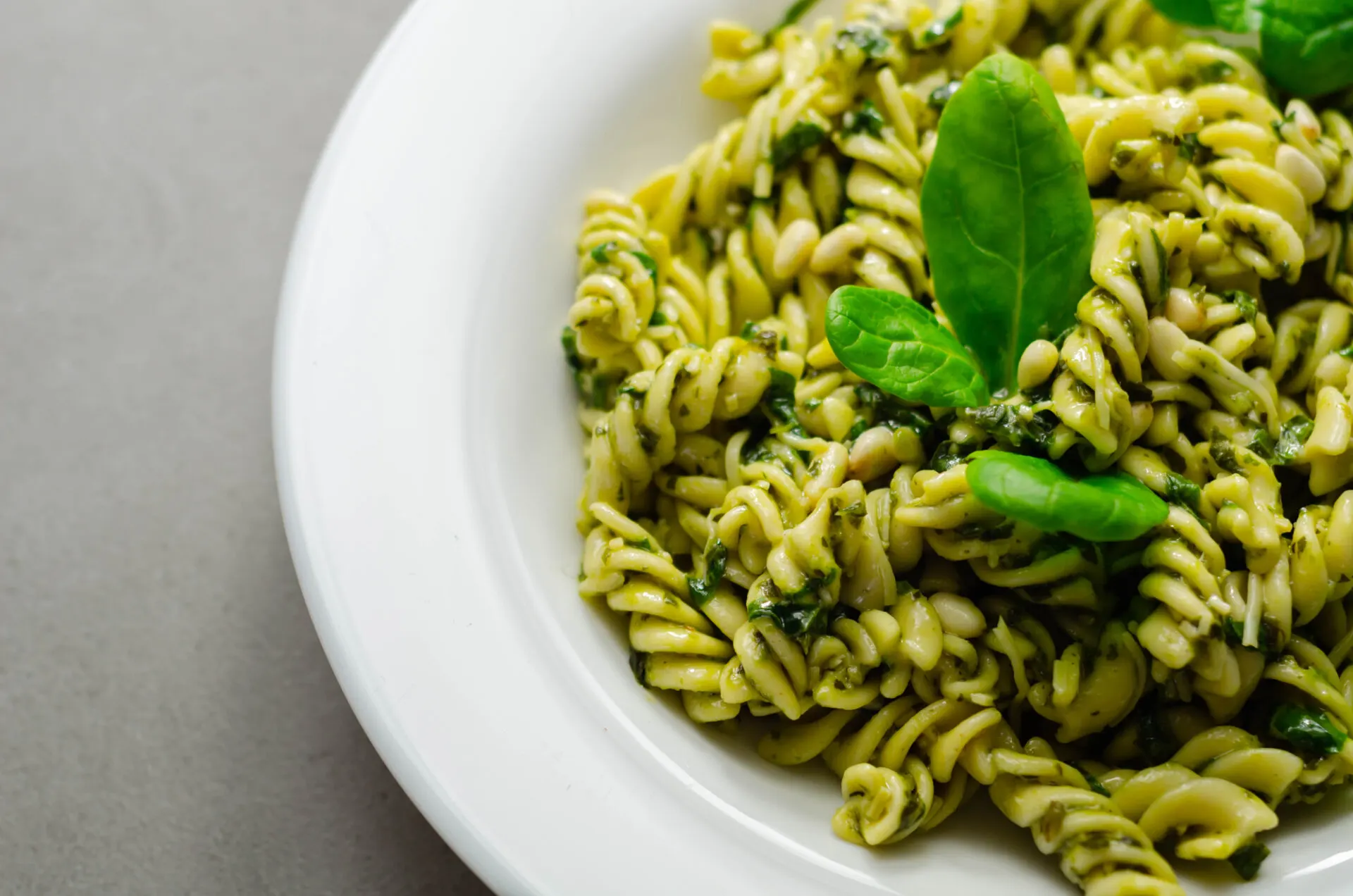 Pesto and pine nut pasta salad, fusilli pasta with regato cheese and baby spinach coated in basil pesto, Italian food