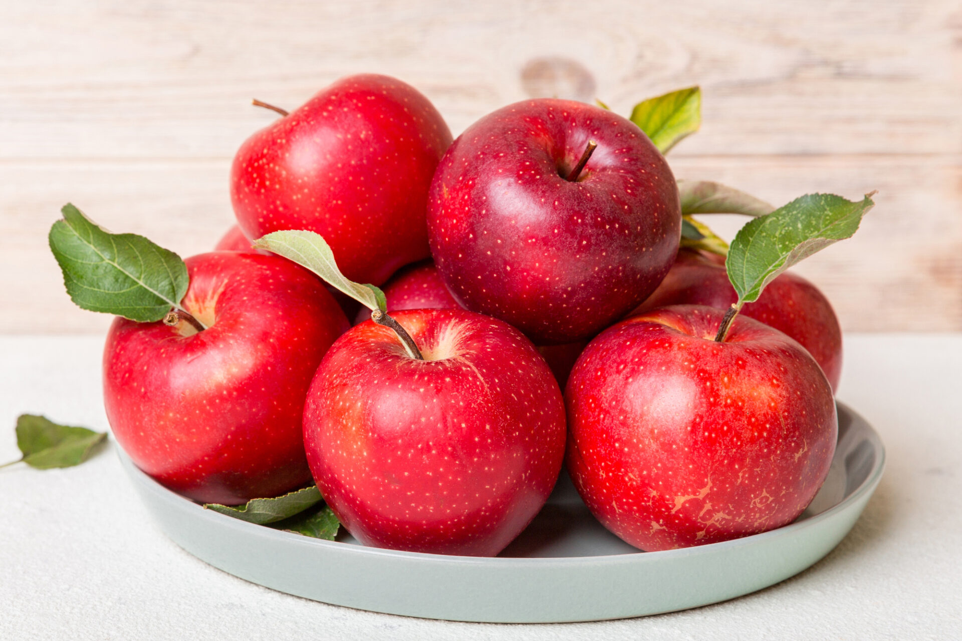 juicy red apples in a bowl or plate on the table top view. Copy space.