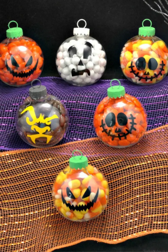 Clear ornaments filled with candy and decorated with Halloween faces for a cute Halloween party favor idea