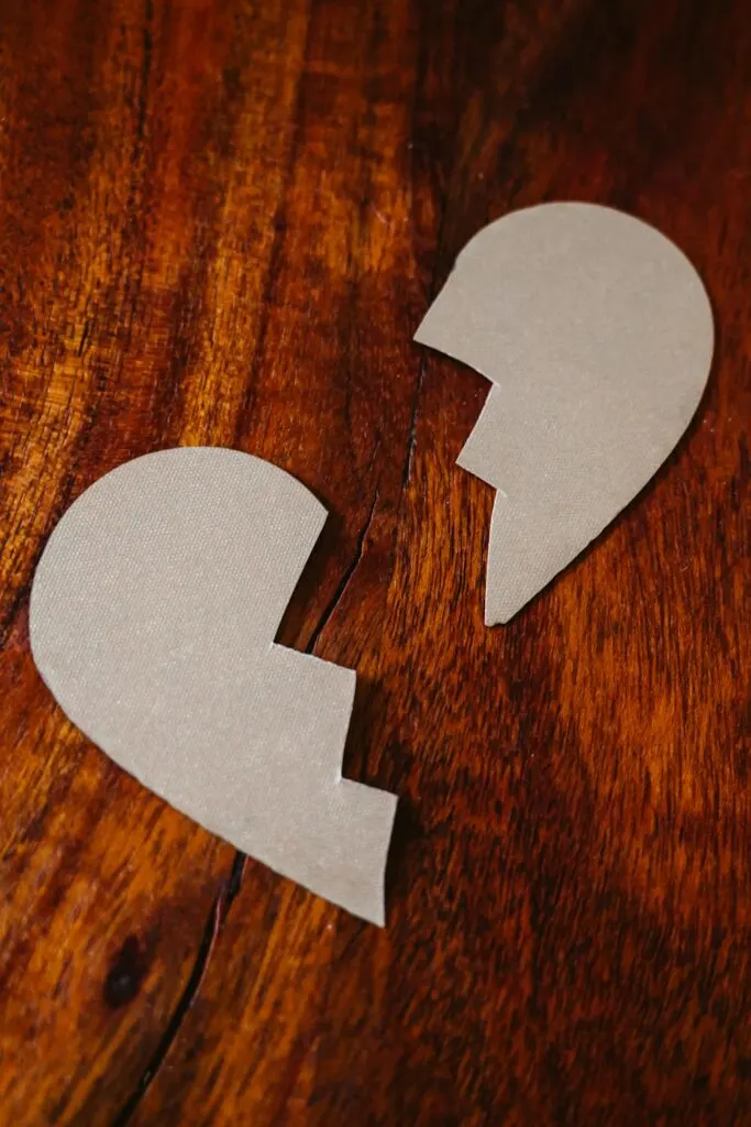 a cardboard heart cut in half depicting a broken heart
