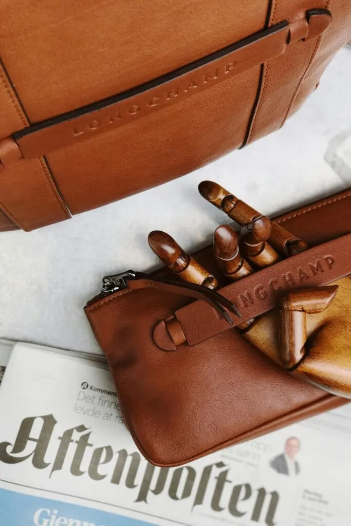 A longchamps french designer bag on a table with a newpaper