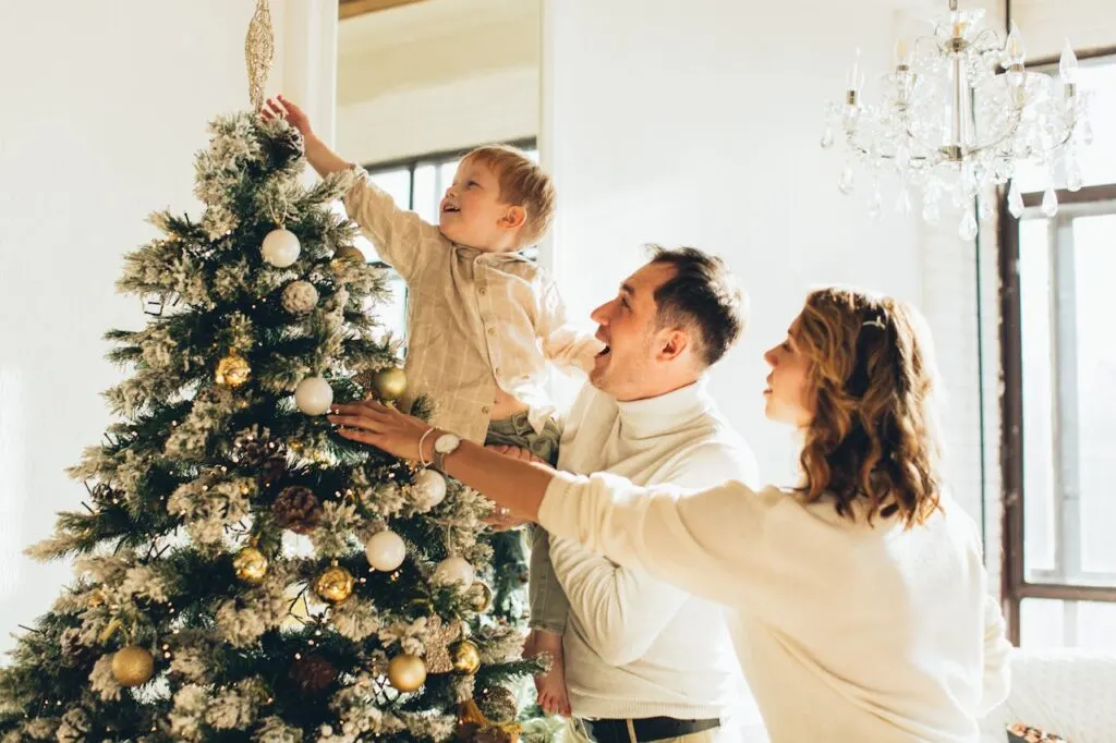 A family decorating the Christmas tree and home using damage-free decorations