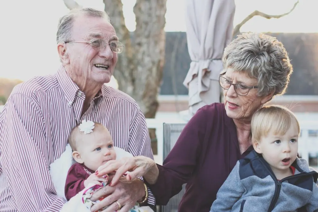 Grandparents holding their grandchildren. Socialization is a key part of maintaining Independence for seniors.