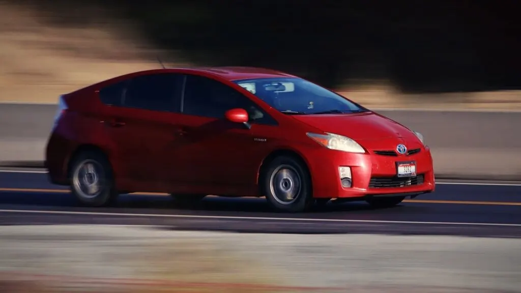 red Prius driving down the road