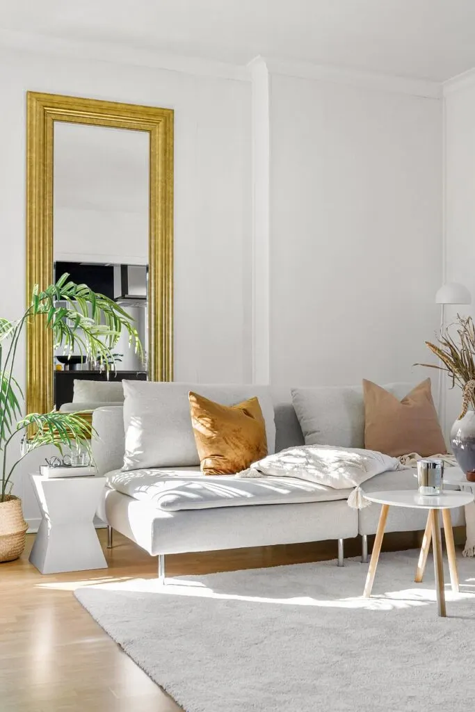 A white couch rug and mirrors are living room decor hacks used to bring this cozy room together.
