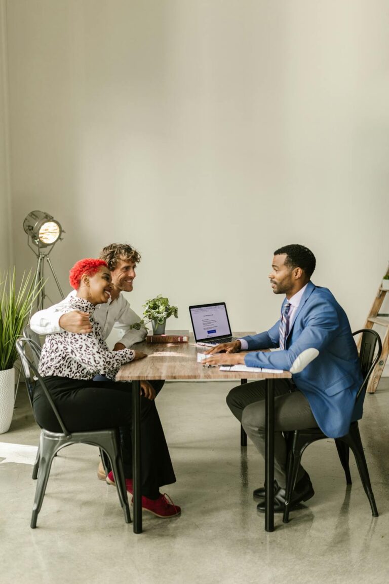 A person discussing life insurance policies with a couple sitting across the desk from him