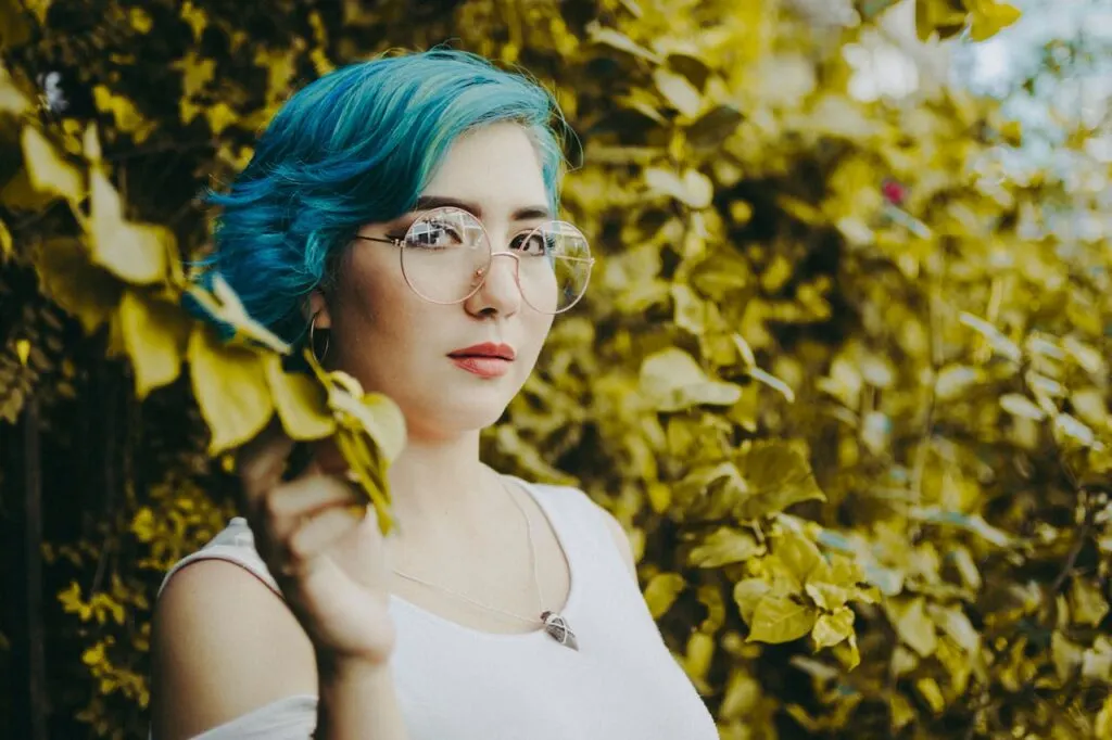 A pretty girl with blue hair posing for the camera full of confidence. These 5 tips can help boost your confidence.