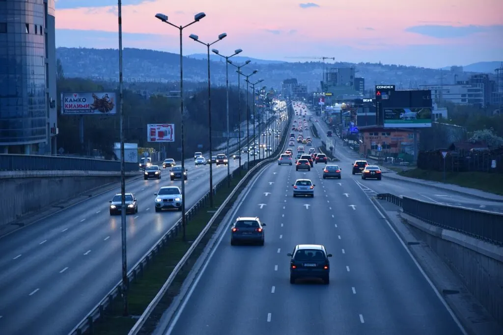 Cars driving on a highway at sunset using vehicle tracking devices