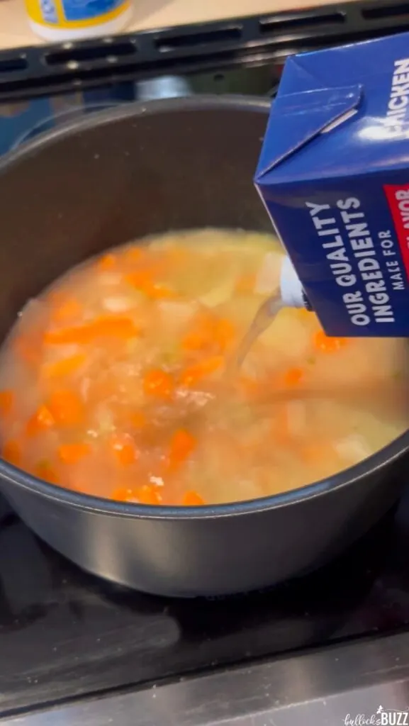 Adding chicken broth to large pot of Cheese Tortellini Soup with Bacon and Spinach