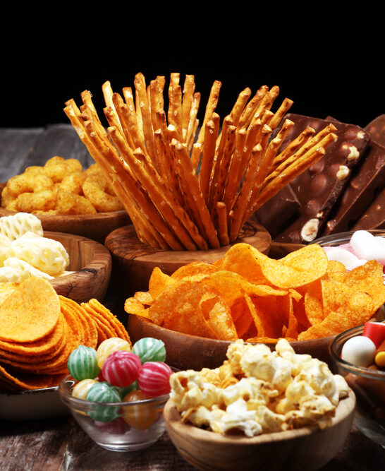 Salty snacks. Pretzels, chips, crackers in wooden bowls on table — Stock Photo, Image