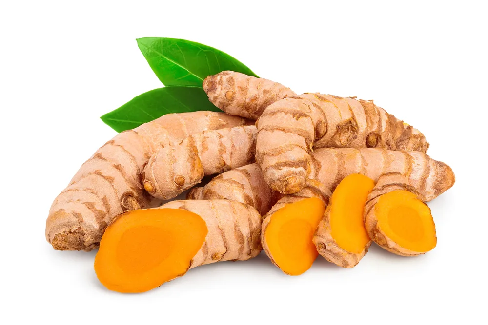 Turmeric root with slices isolated on white background
