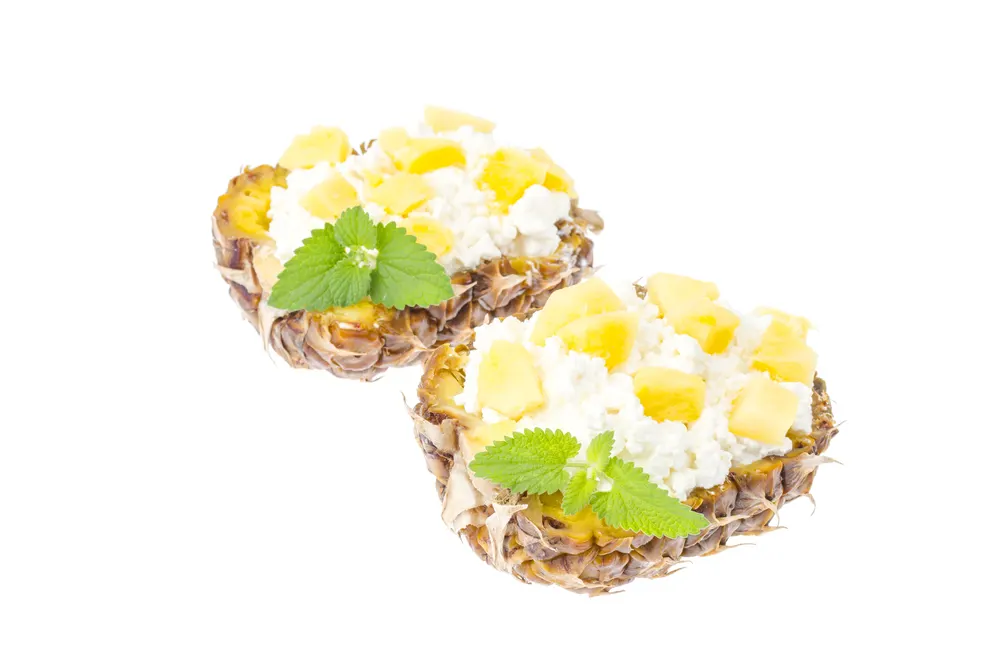 Diet menu. Weight loss program. Dairy products and fruits. Homemade cottage cheese in half pineapple. Studio Photo