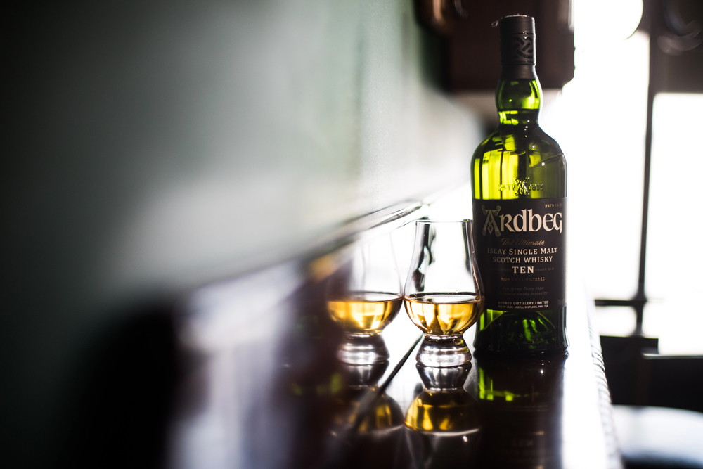 Bucharest, Romania - March 3, 2021: Illustrative editorial image of a Ardbeg single malt whisky bottle and a Glencairn glass displayed in a pub in Bucharest, Romania. — Photo by bizoon