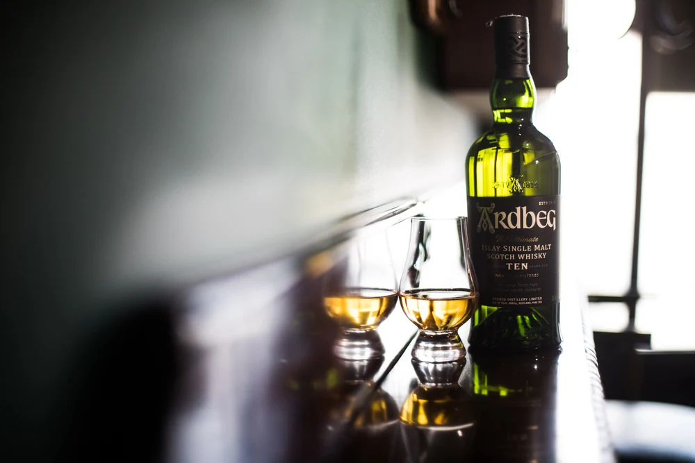 Bucharest, Romania - March 3, 2021: Illustrative editorial image of a Ardbeg single malt whisky bottle and a Glencairn glass displayed in a pub in Bucharest, Romania. — Photo by bizoon