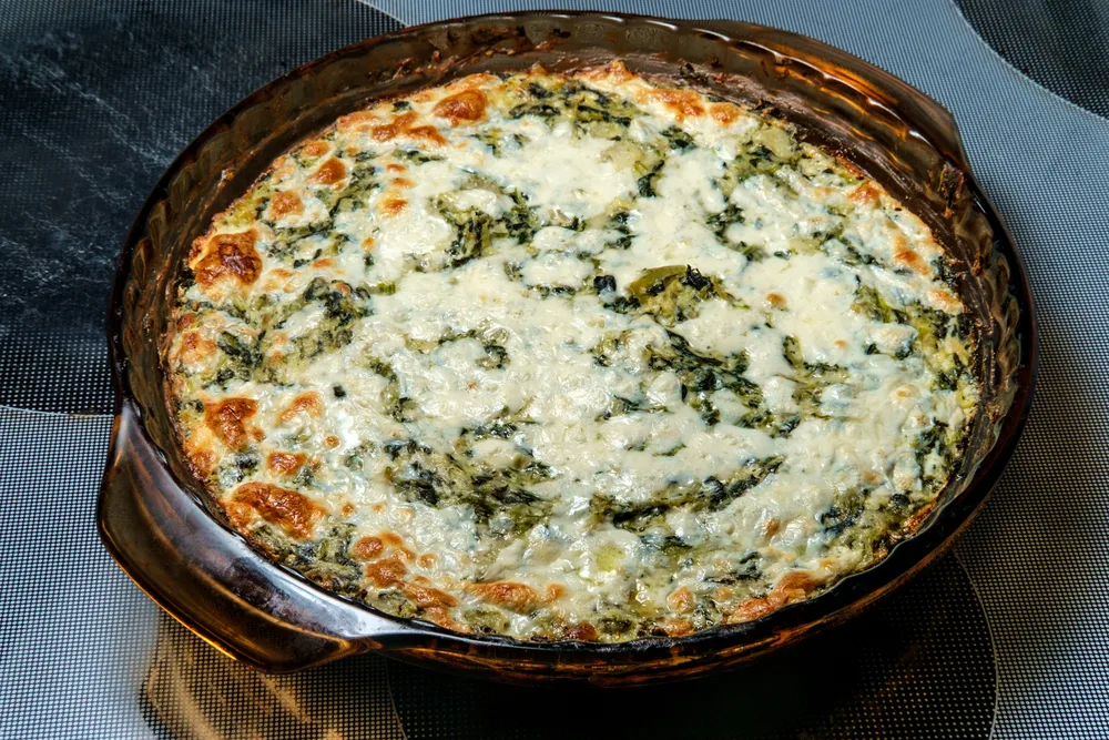 Baked cheesy artichoke spinach dip in oven pan
