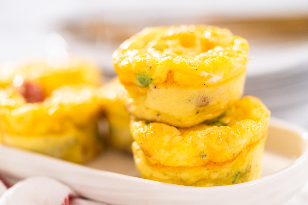 Bacon and cheese egg muffin on a white serving plate. — Photo
