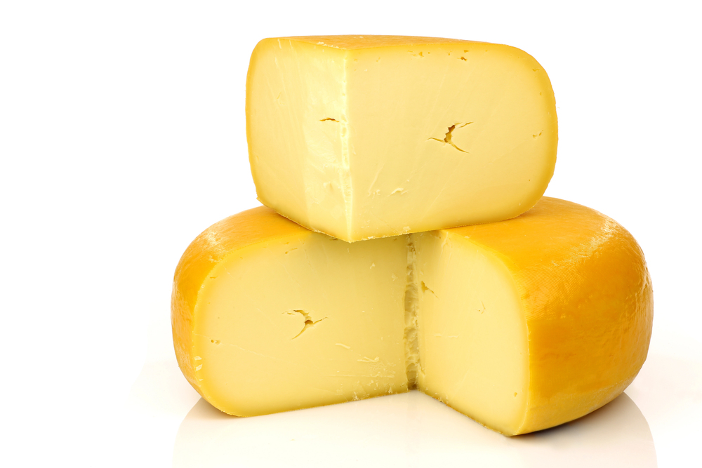 Traditional Dutch Gouda cheese with a piece on top — Photo