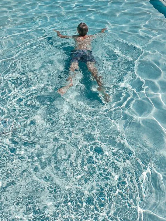 a child swimming in a fiberglass pool