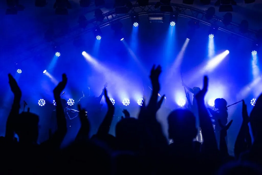 People dancing to live music under blue lights at a popular venue, a key part of knowing how to plan the perfect night out.