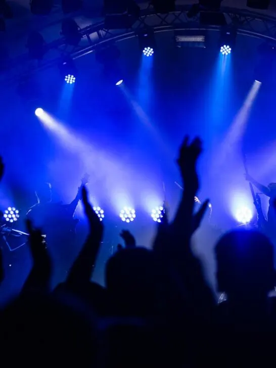 People dancing to live music under blue lights at a popular venue, a key part of knowing how to plan the perfect night out.