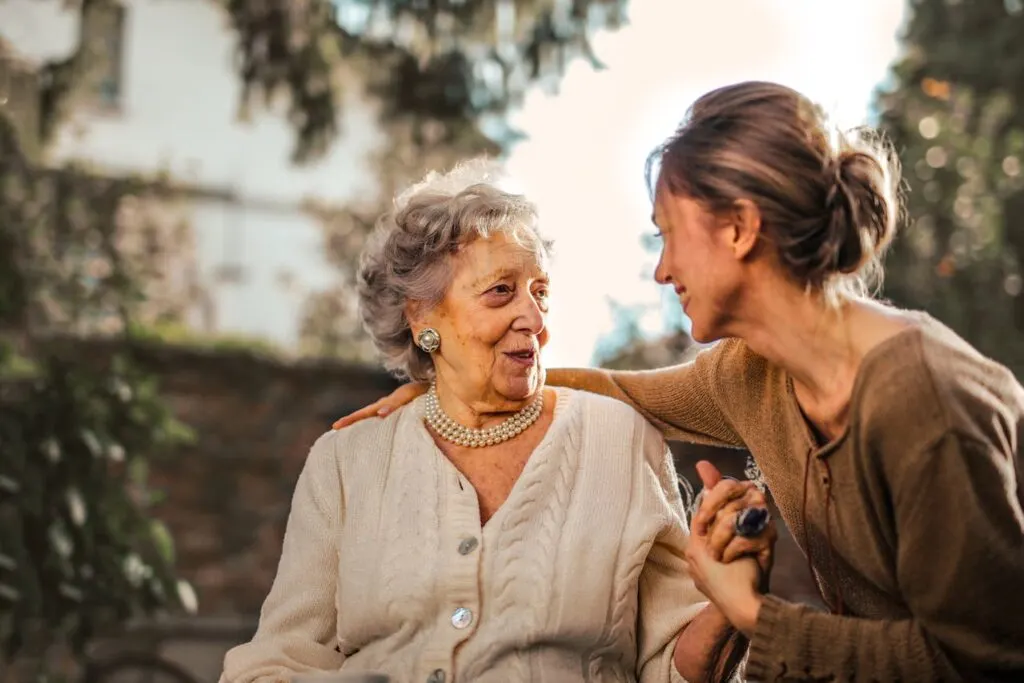 A woman talking to her elderly mom providing social interaction is part of creating a supportive environment for memory care